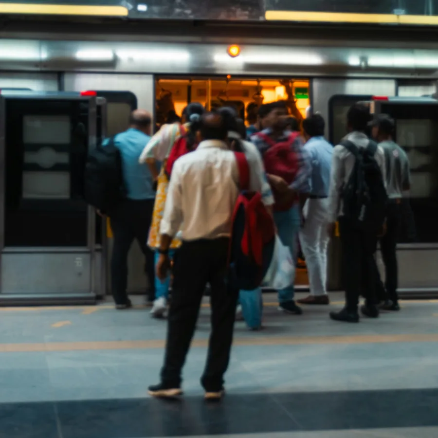 An underground platform, travellers seen from behind at the doors of a train