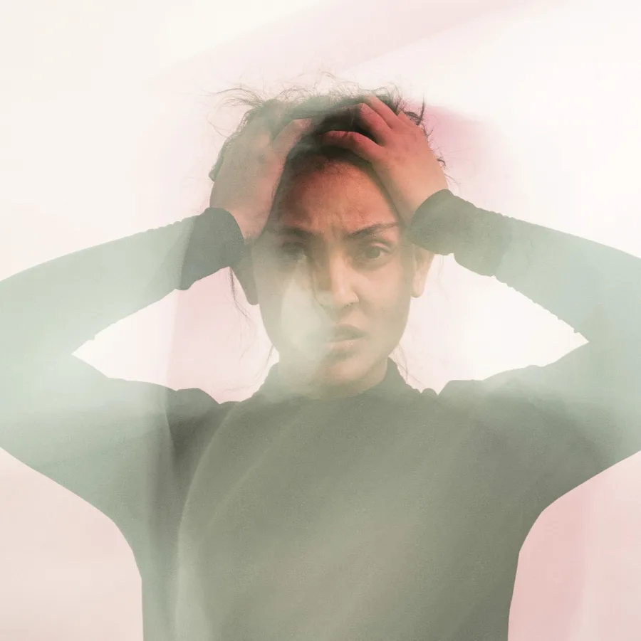Woman with her hands on her head, image veiled in mist