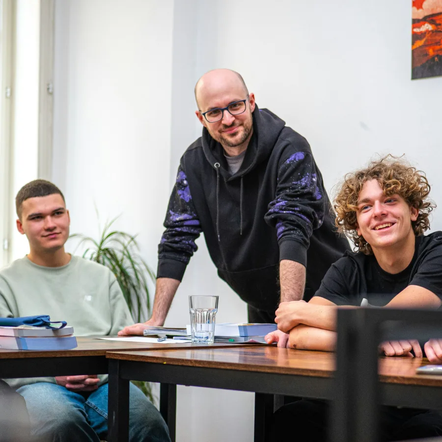 Trois personnes autour d'une table de travail, dans une salle claire