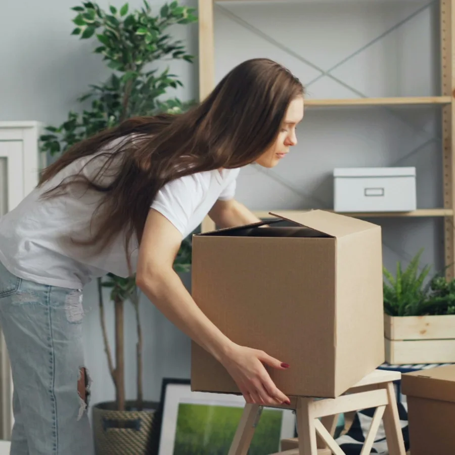 Persona ordenando tranquilamente cajas en un desván luminoso, a plena luz del día