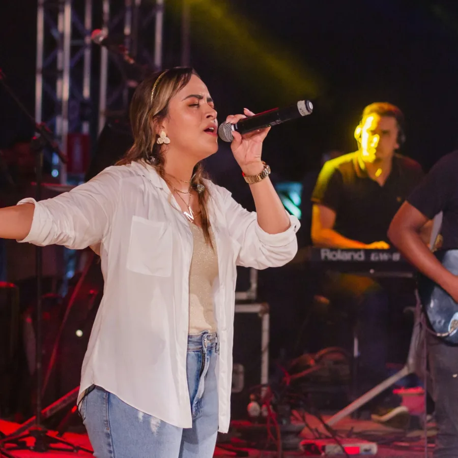 A singer on stage, eyes closed, absorbed in the music