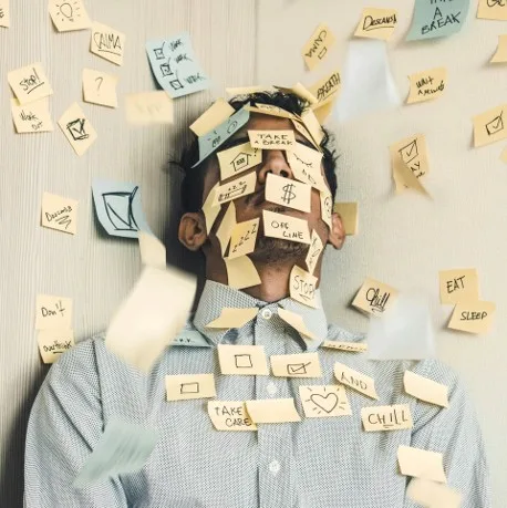 Person covered in sticky notes listing things to be done