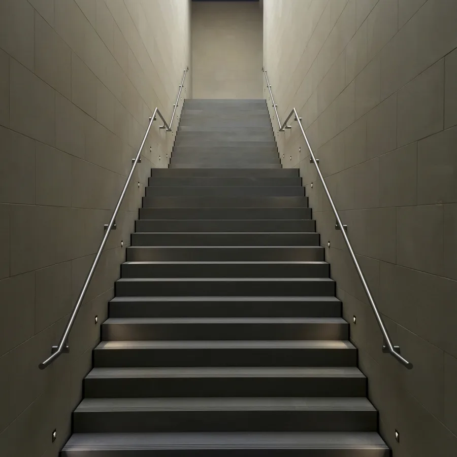 Una escalera clara vista desde abajo, con los peldaños subiendo hacia la luz