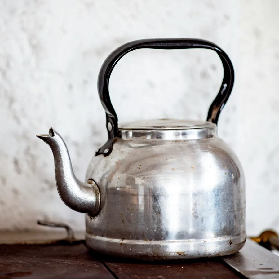 An old metal kettle standing on a stove