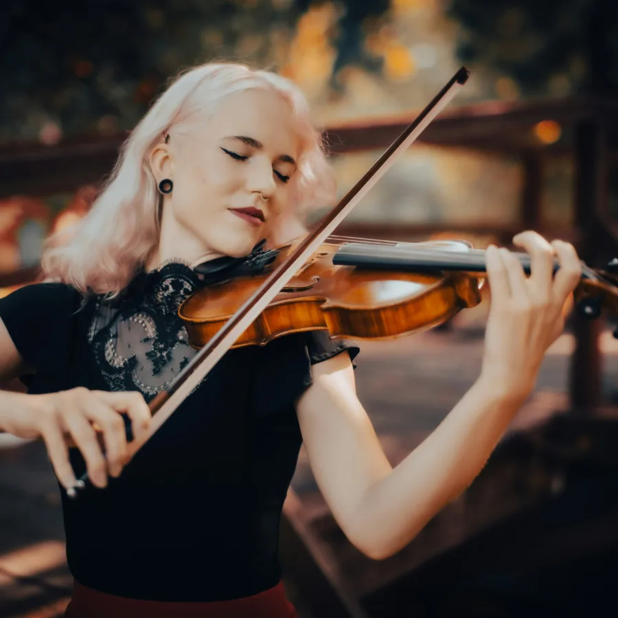 A violinist playing with her eyes closed, absorbed in the music