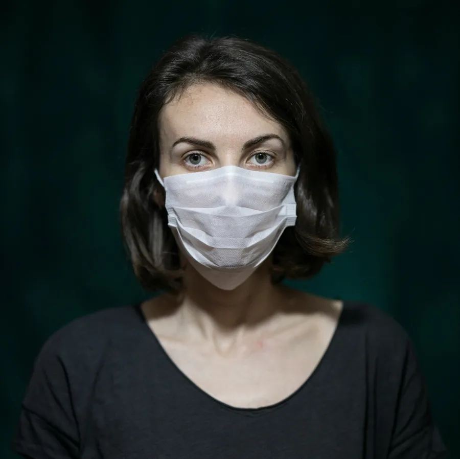 Woman wearing a surgical mask, a steady look