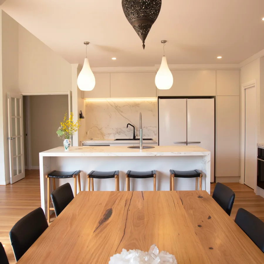 Mesa de cocina vacía en una casa silenciosa, con luz de final del día