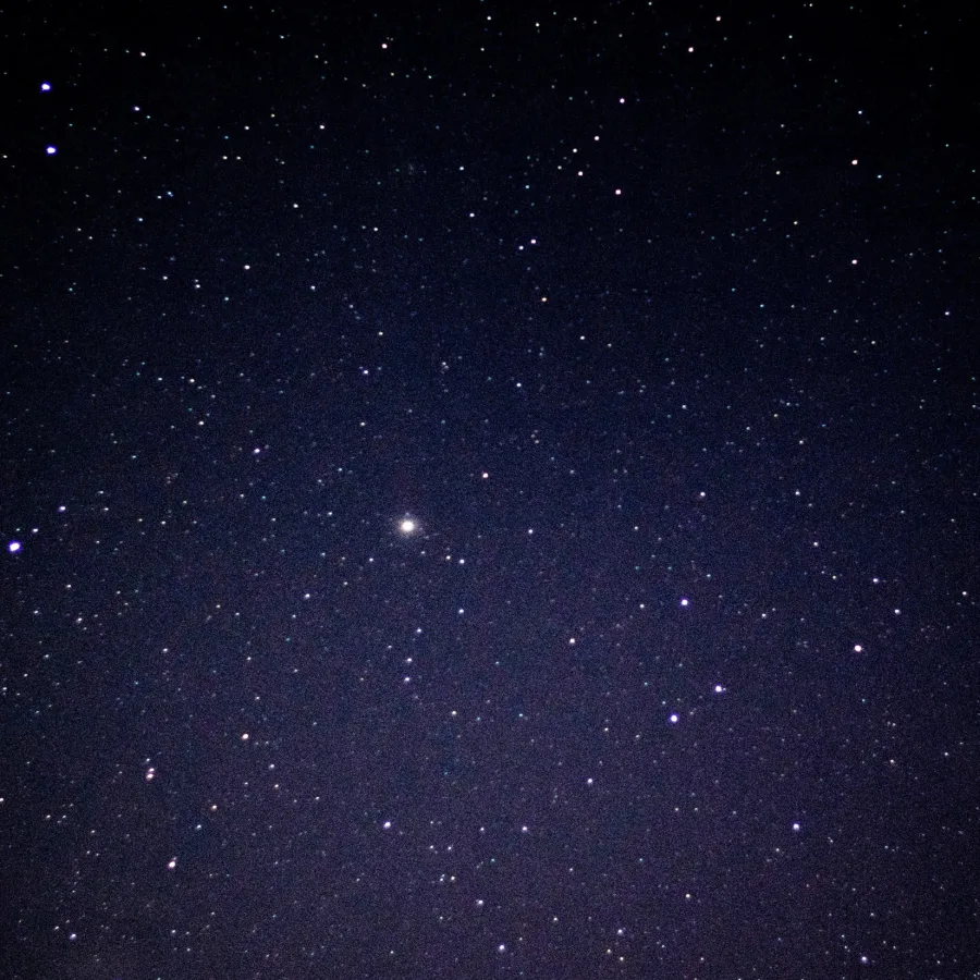 Cielo estrellado de noche, con una estrella más brillante en el centro