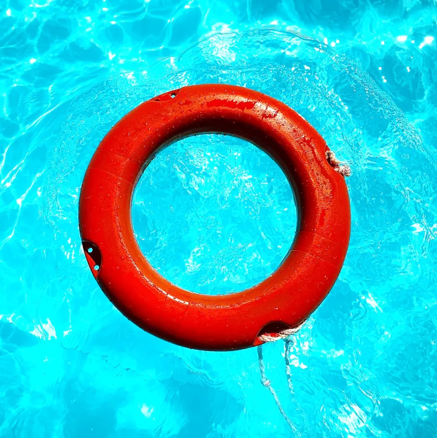 Salvavidas rojo flotando en la superficie de una piscina