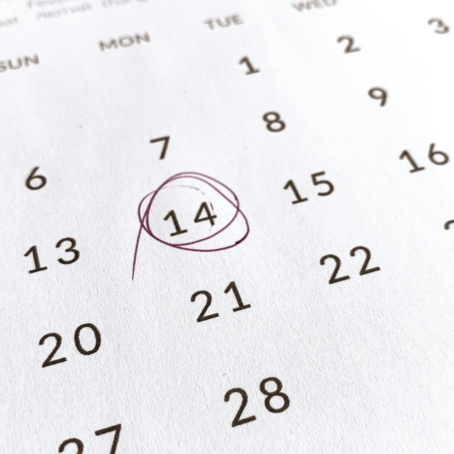 Wall calendar with the 14th circled in pen