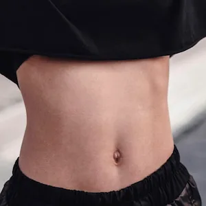 Vientre de una persona vestida con una camiseta y un pantalón negros