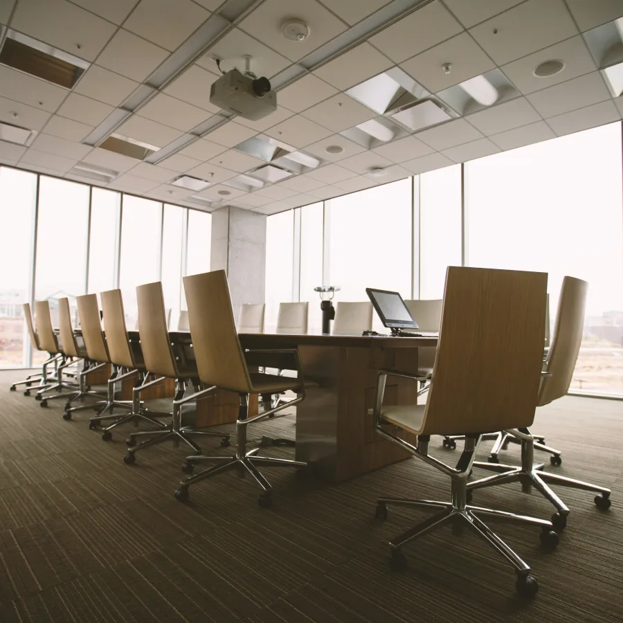 Sala de reuniones acristalada, todavía vacía, con sus sillones alineados