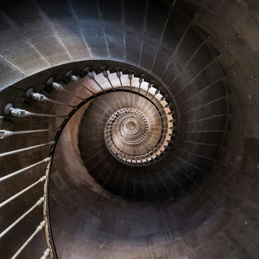 A spiral staircase seen from above, its coils closing in on themselves