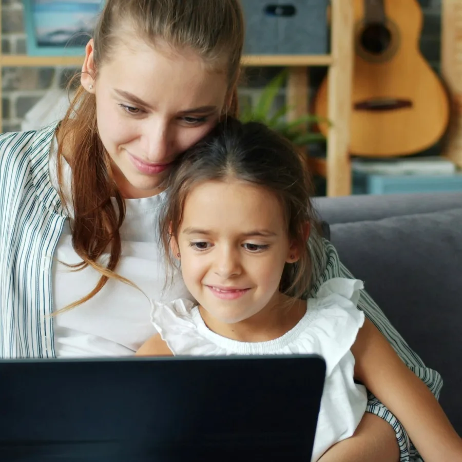 Parent and child sitting in front of a laptop at home