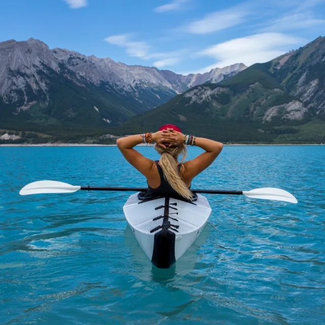 Personne détendue en kayak, face à un lac de montagne