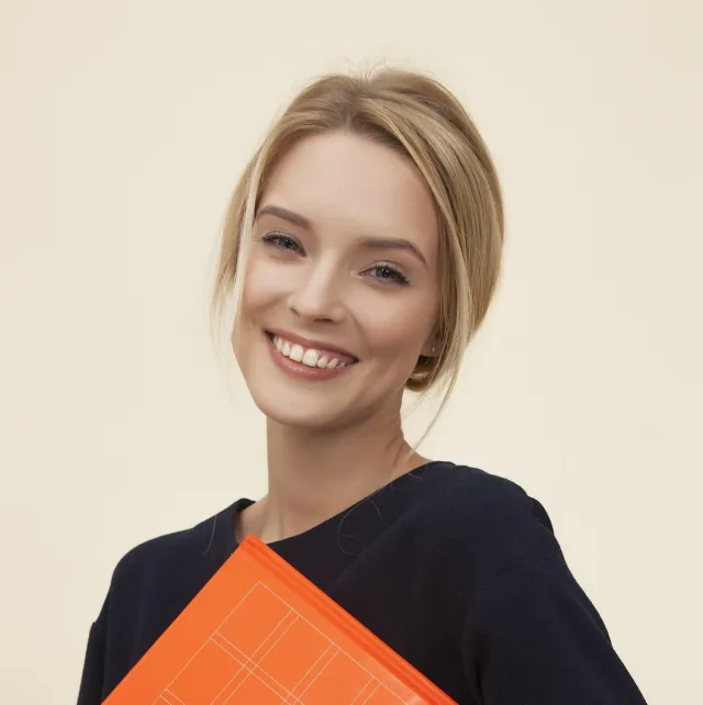 Smiling young woman holding an orange folder under her arm