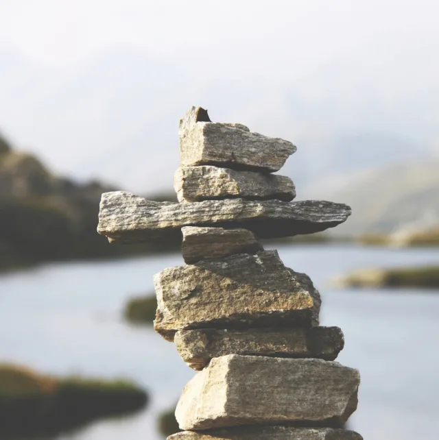 Cairn de pierres en équilibre au bord d'un lac calme
