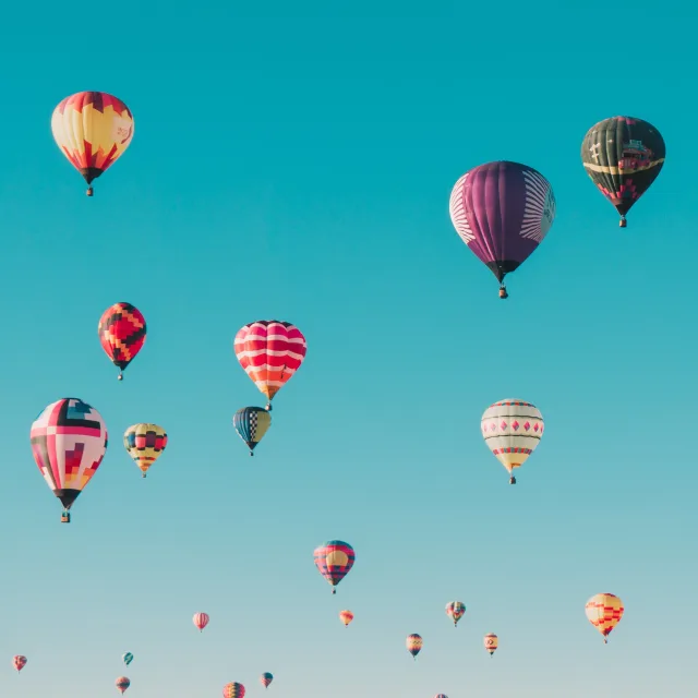 Montgolfières colorées s'élevant dans un ciel bleu