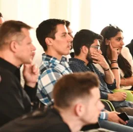 Public attentif dans une salle, un auditeur pensif au premier plan