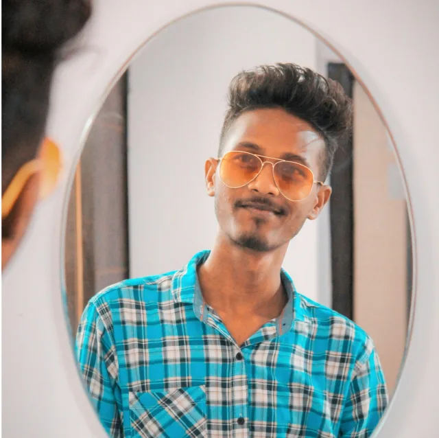 Jeune homme souriant et sûr de lui, se regardant dans un miroir