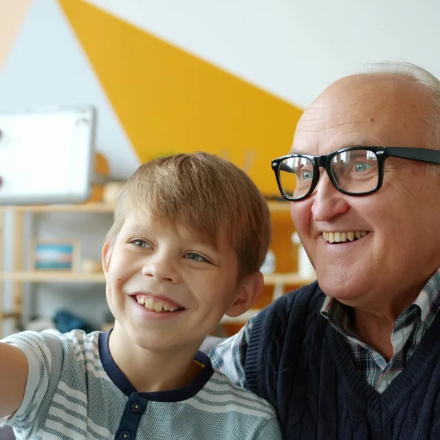 Un grand-père et son petit-fils souriants, prenant un selfie ensemble