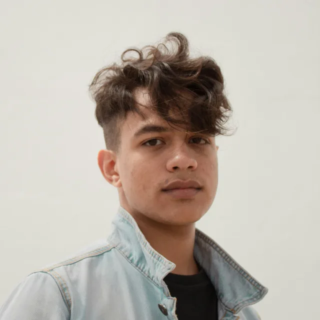 Teenager in a denim jacket, looking at the camera